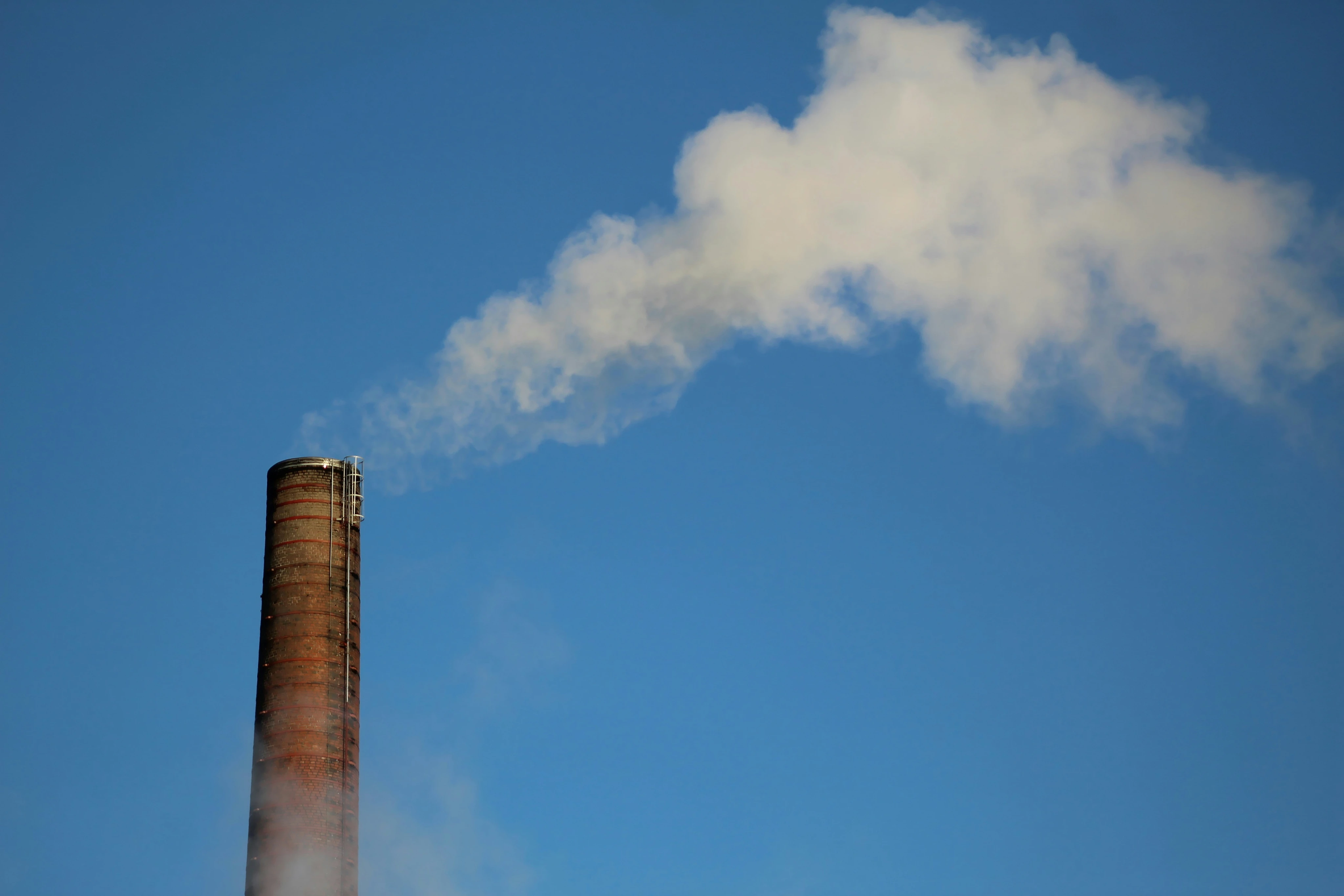 Chimenea industrial ante un cielo azul con nubes